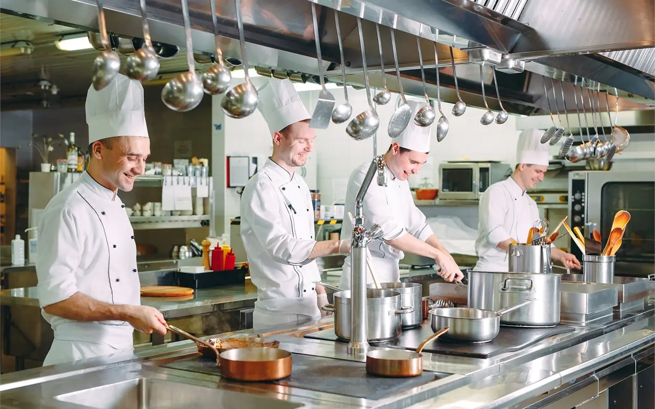 Chef che salta verdure in una wok in cucina professionale