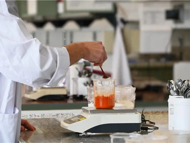 Tecnologo Almi che pesa gli ingredienti di una nuova ricetta su bilancia di precisione